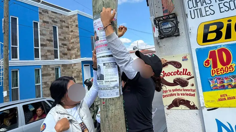 familiares pegan ficha de búsqueda